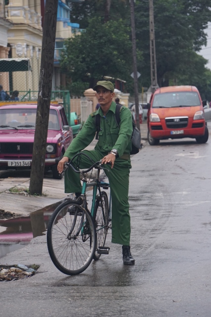 Man riding a bike in the streets of Havana.